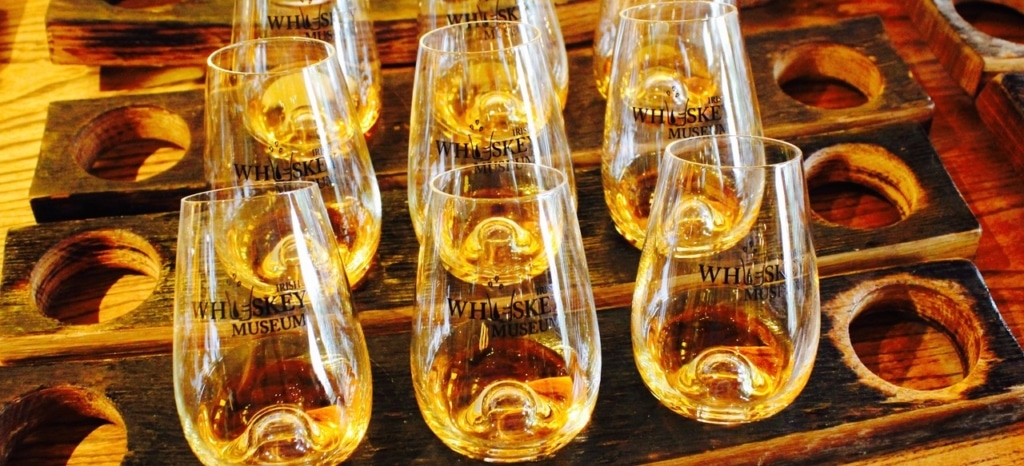 whiskey testing glasses on a wooden platter